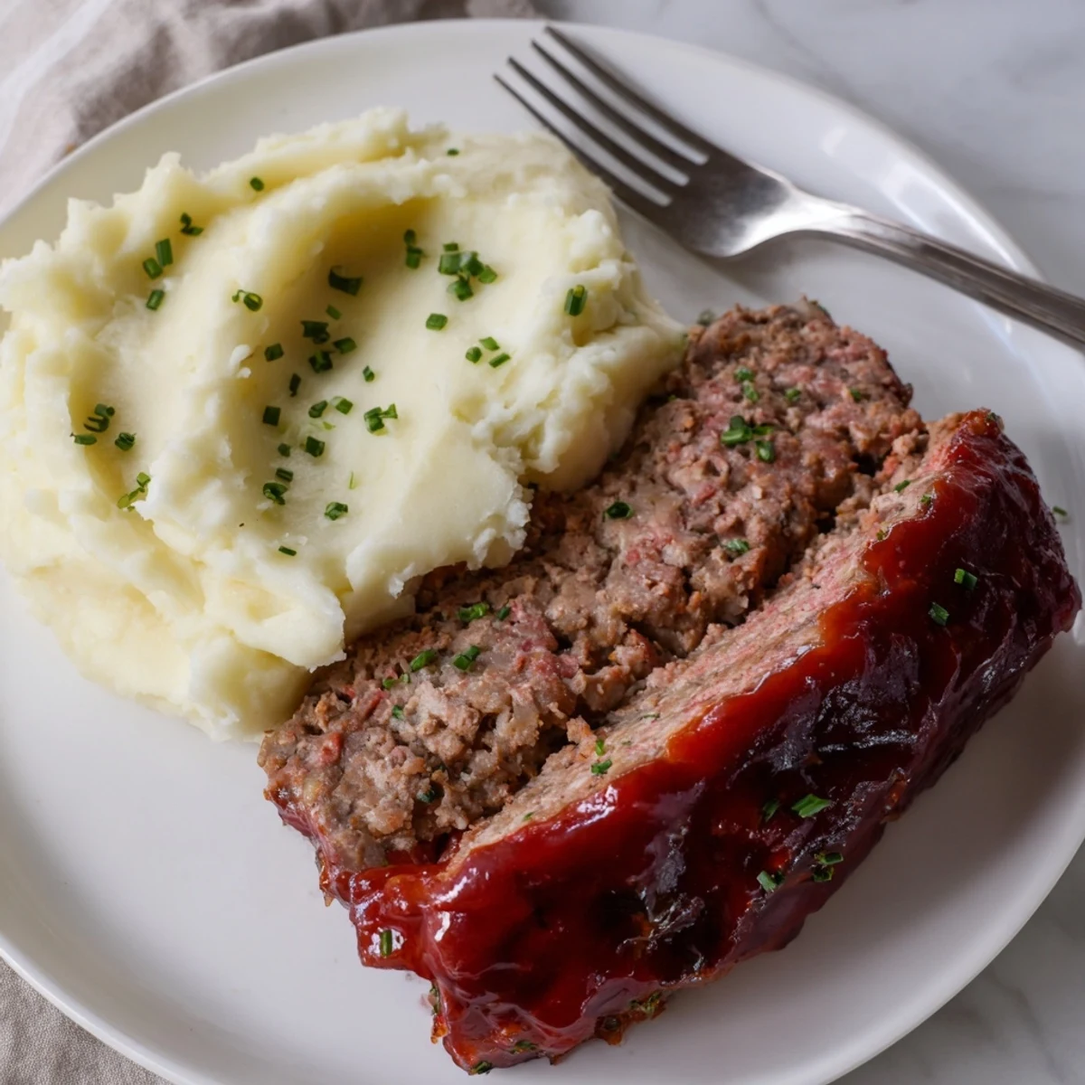 Deliciously comforting Classic Meatloaf with creamy mashed potatoes, perfect for family gatherings.  