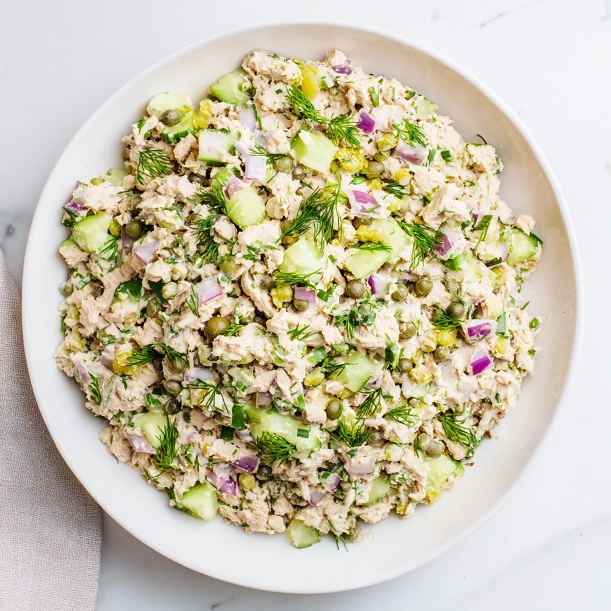 Vibrant chickpea tuna salad, speckled with green herbs and red onion, ideal with crusty bread.
