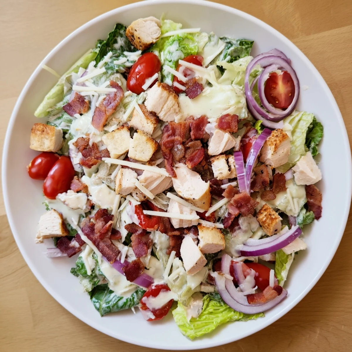 This fresh Costco Chicken Bake Salad Bowl presents a vibrant mix of ingredients and a creamy Caesar dressing in a bowl.