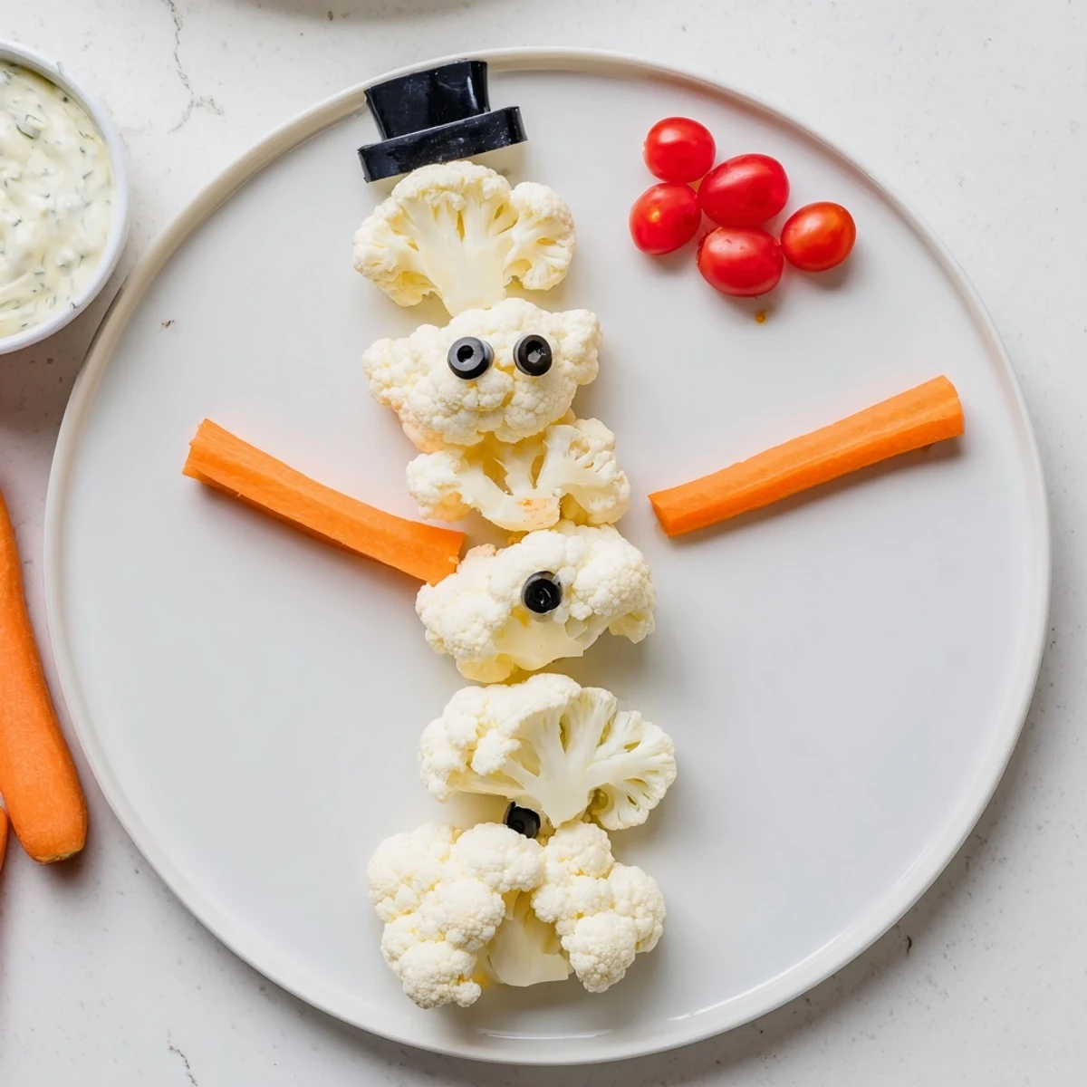 Crisp carrot arms and a bell pepper hat adorn the adorable Snowman Crudités, ready for dipping.