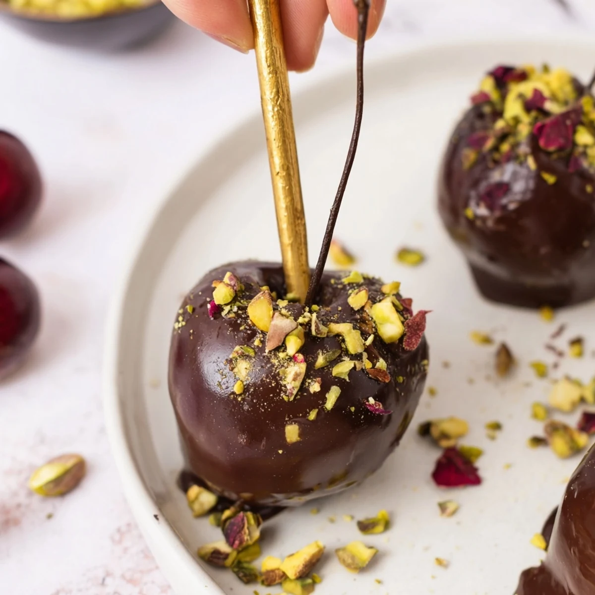 Decadent chocolate-covered cherry dessert bites arranged in a beautiful pyramid, perfect for celebrations.