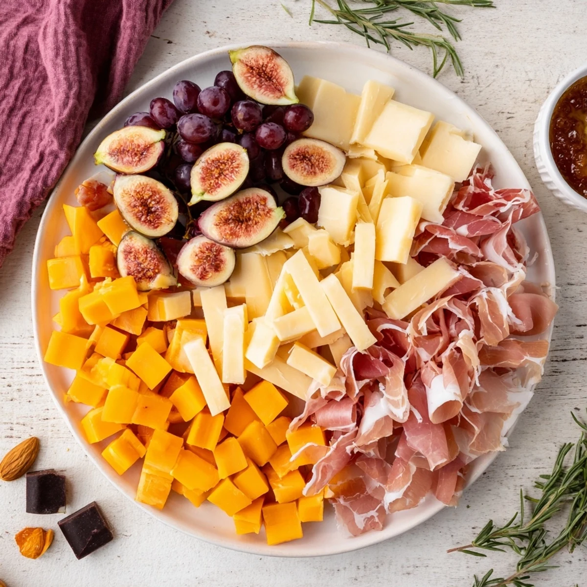 Anniversary heirloom arrangement boasts cheeses, meats, and fruit artfully arranged on a wooden board.