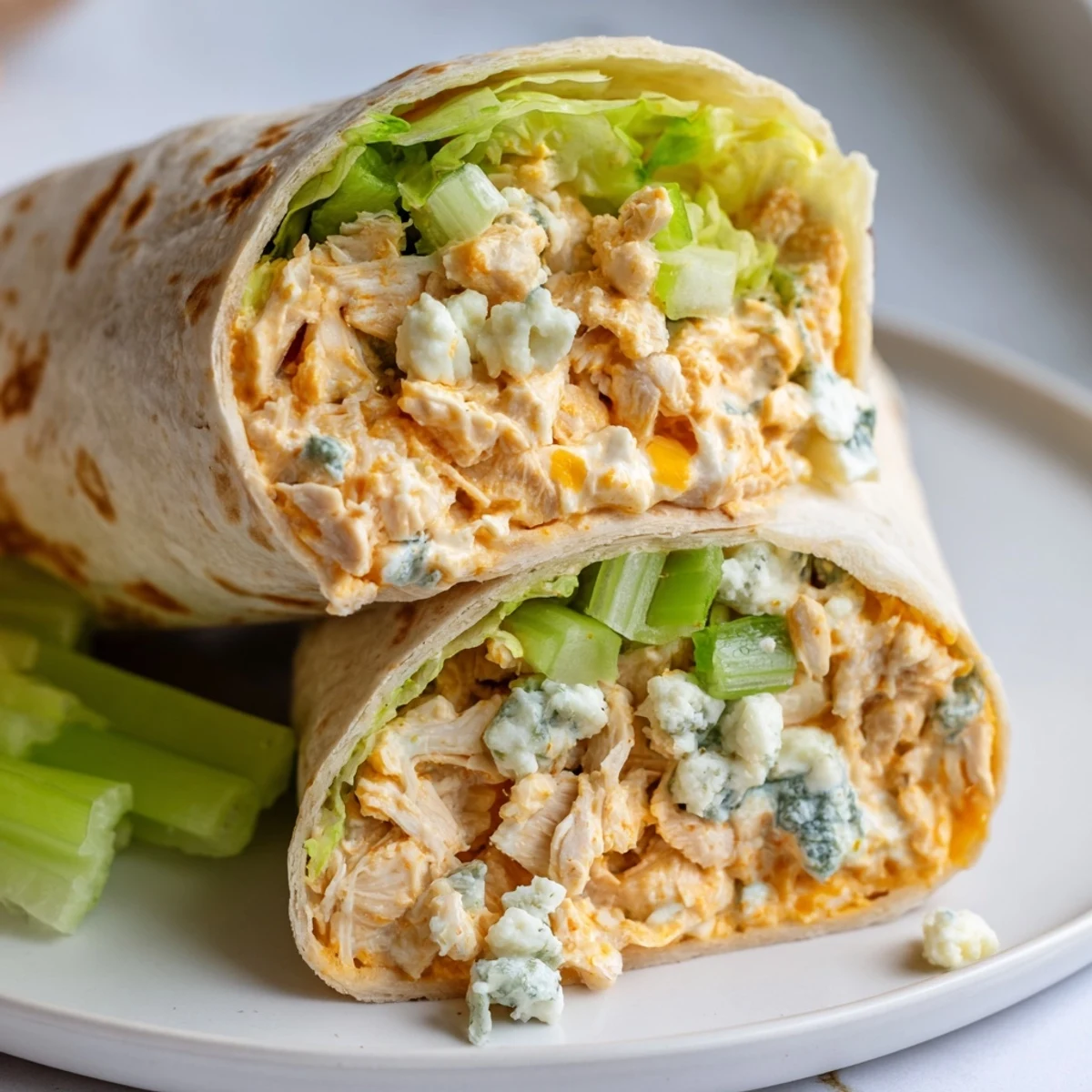 Buffalo chicken dip wraps, deliciously melty, with creamy filling visible inside golden flour tortillas.