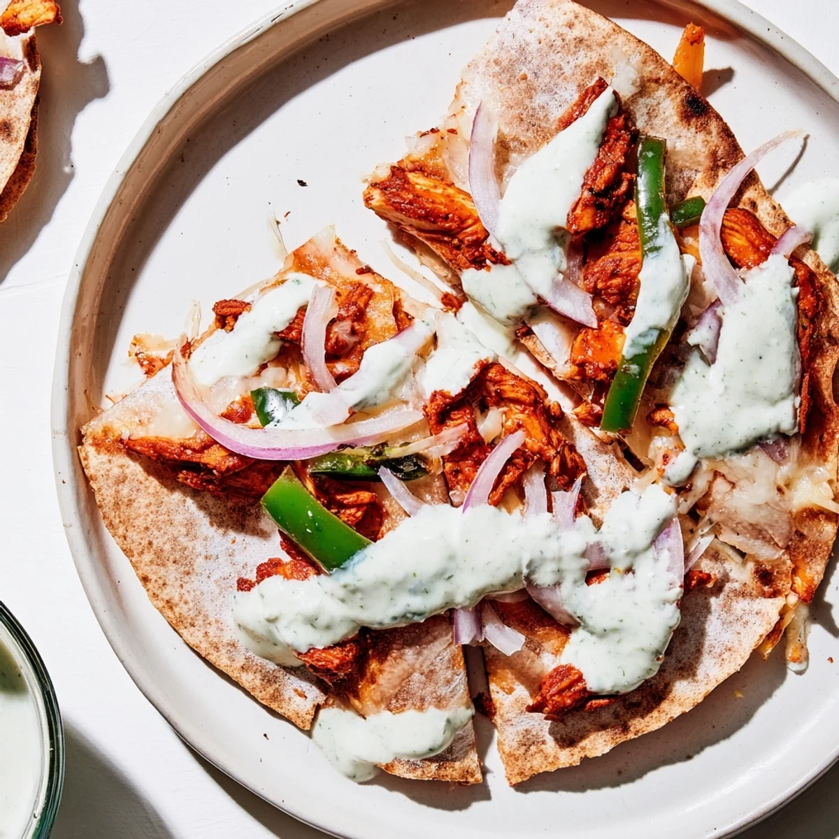 Imagine a warm Tandoori Chicken Quesadilla, featuring seasoned chicken and a flavorful yogurt sauce, ready to serve.