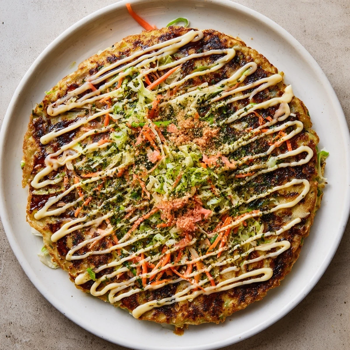 Golden-brown Japanese Okonomiyaki Pancakes sizzling on a griddle, topped with creamy mayonnaise, tangy sauce, and dancing bonito flakes.