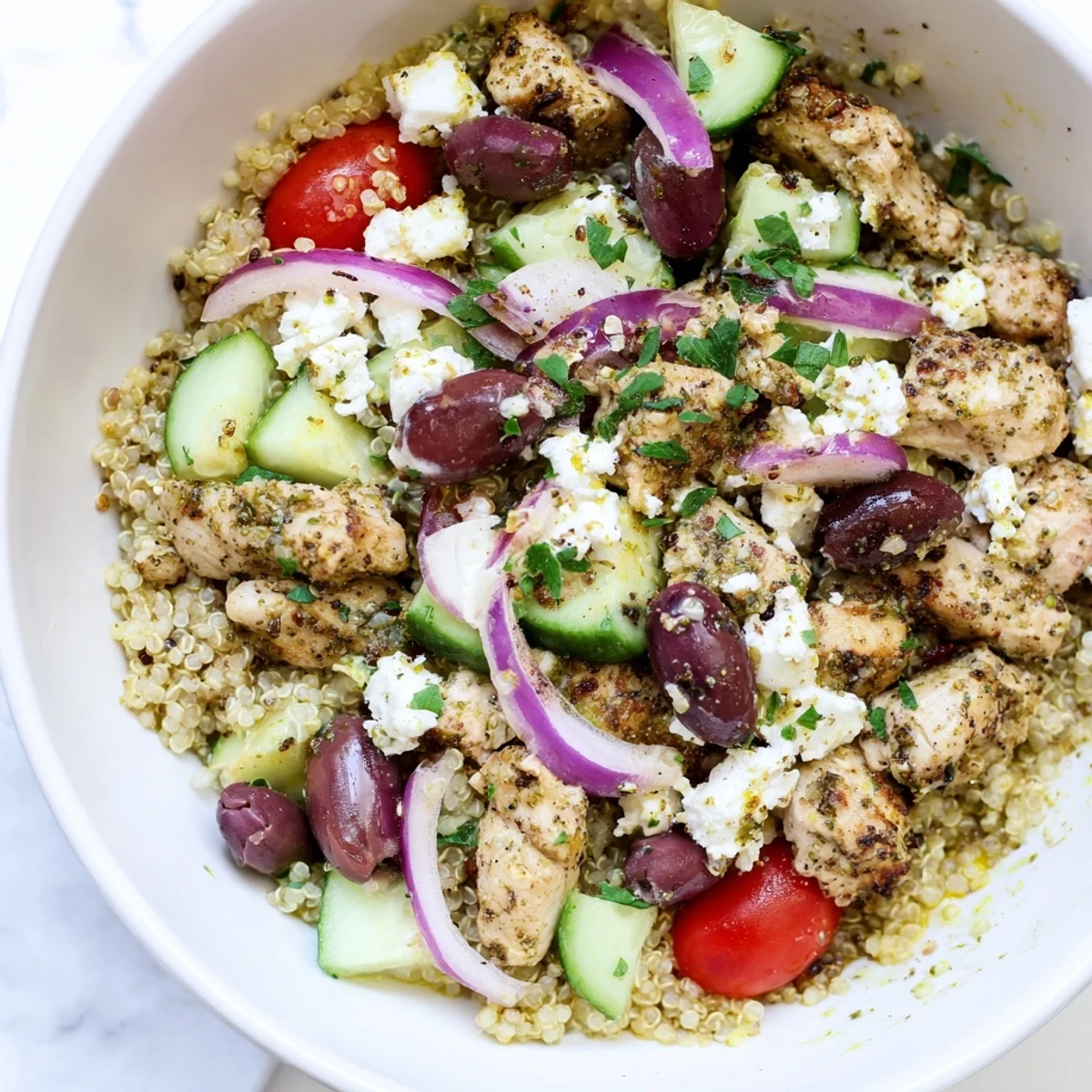Mediterranean Chicken Bowl served in a rustic bowl, featuring juicy chicken, tangy olives, and creamy feta cheese.