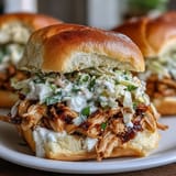 Tender shredded chicken slow-cooked with ranch and au jus, served on soft slider buns with tangy coleslaw.  
