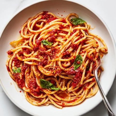 Steaming plate of spaghetti with homemade marinara sauce, garnished in fresh basil.  