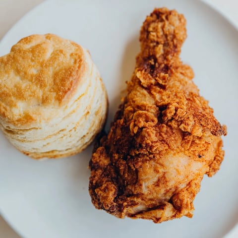 Golden-brown Southern Fried Chicken served alongside fluffy buttermilk biscuits, a delicious family meal.