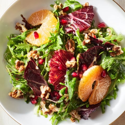 A colorful Winter Greens Salad with citrus, pomegranate, and toasted nuts, ready to enjoy.