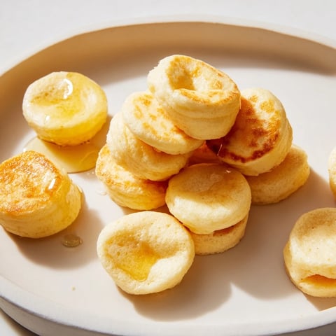 Golden mini pancake cereal swimming in a bowl, perfect for a fun and easy breakfast.