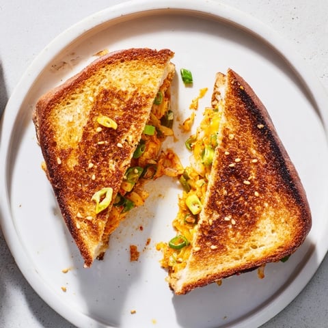 Golden, melty Skillet Kimchi & Cheddar Fusion Grilled Cheese, oozing with cheese and tangy kimchi.