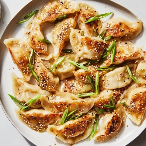 Golden brown air fryer frozen dumplings glazed with sesame oil, ready to serve and enjoy.