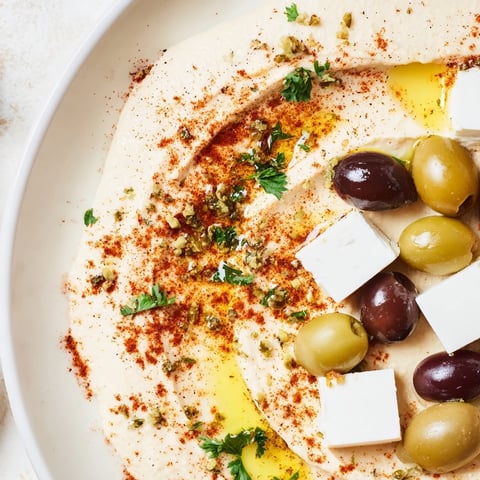 A close-up of a vibrant Middle Eastern Mezze Platter with creamy hummus, feta cubes, and crisp vegetables.