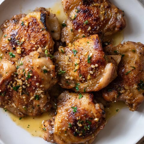Golden, crispy chicken thighs in rich garlic butter sauce, ready to serve.  