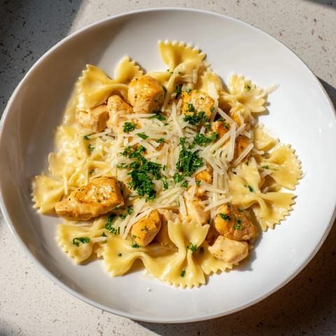 A close-up of golden mozzarella garlic butter chicken bowties, perfectly cooked with a rich, savory sauce.