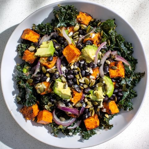 Close-up of freshly made massaged kale salad offering a nutritious lunch, full of black beans and sweet potato.