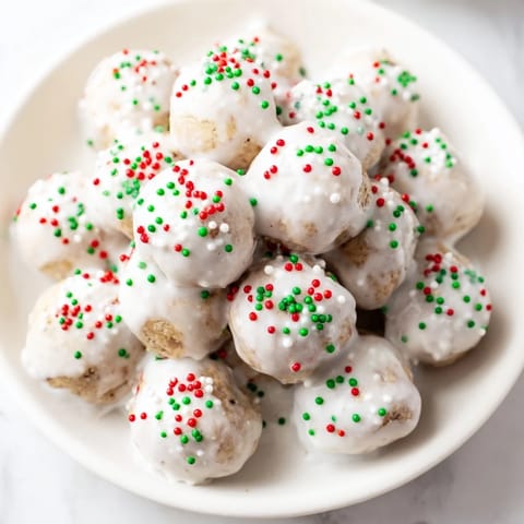 Freshly baked Protein-Packed Italian Christmas Cookie Balls with a sweet glaze and colorful sprinkles.
