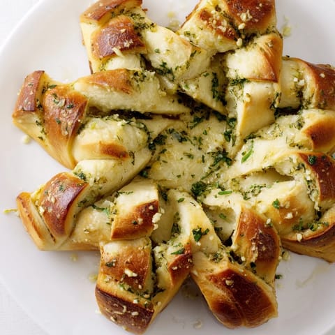 Fluffy, aromatic star shaped garlic bread: baked golden and ready to be pulled apart with herbs.
