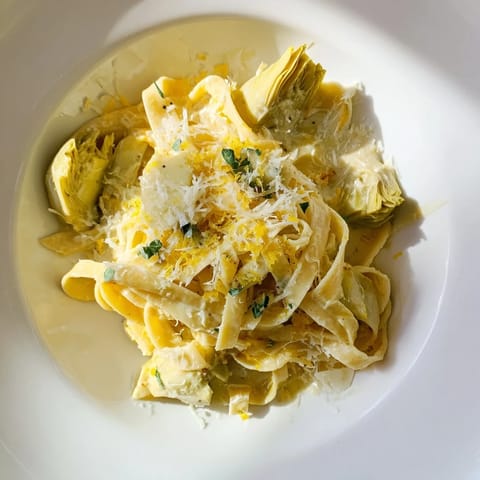 A close-up shot of Creamy Lemon Artichoke Pasta, showcasing the creamy sauce and pasta.