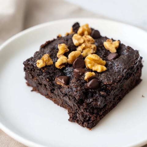 A plate of rich, gluten-free black bean brownies, perfect for a satisfying dessert treat.