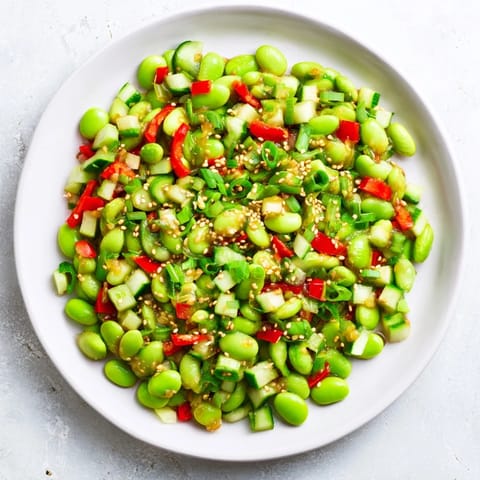 A close-up of a refreshing edamame salad, showing the crunchy cucumber and sesame dressing.