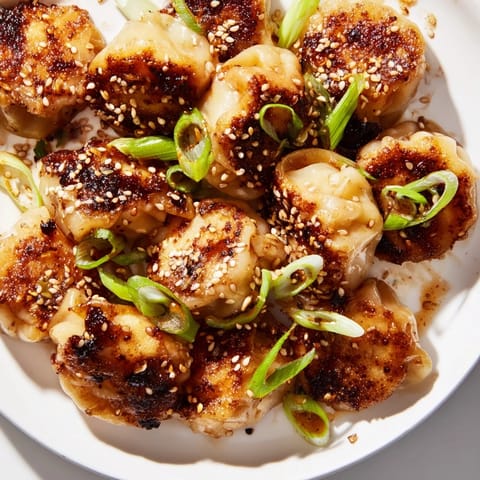 Crispy air fryer frozen dumplings, glistening with sesame oil, garnished with fresh green onions.