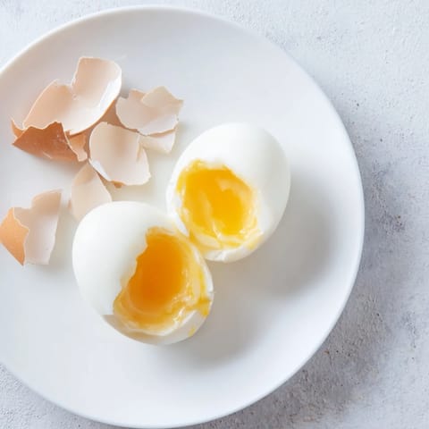 This photo displays perfectly cooked Air Fryer Boiled Eggs, with bright yellow yolks and smooth whites.
