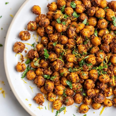 Vibrant plate of Harissa Chickpea Roast, a vegan snack, roasted until perfectly crunchy and delicious.