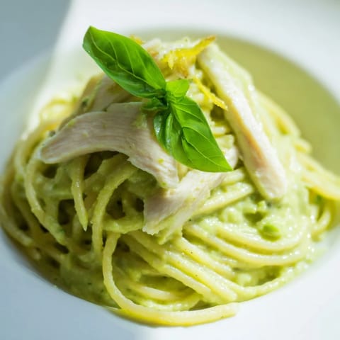 Creamy avocado chicken pasta tossed in a silky green sauce served warm with optional Parmesan.