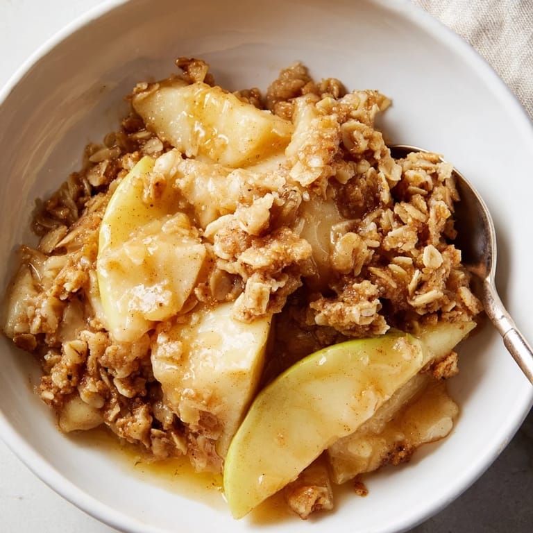 Enjoy Warm Apple Crisp, featuring sweet apples under a crunchy oat layer and creamy toppings.