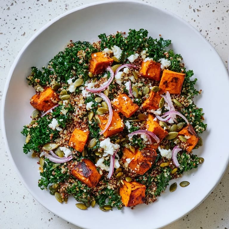 A colorful bowl of fresh Kale & Quinoa Salad: textures like fluffy quinoa, sweet potato cubes.