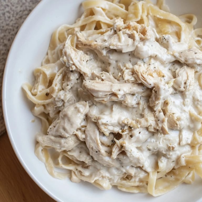 Slow-cooked Creamy Chicken Alfredo, featuring juicy chicken and a luscious Alfredo sauce with garlic.