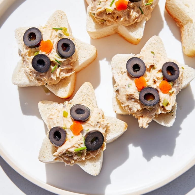 These festive Mini Starfish Sandwiches feature tuna filling and are decorated with olives and capers.