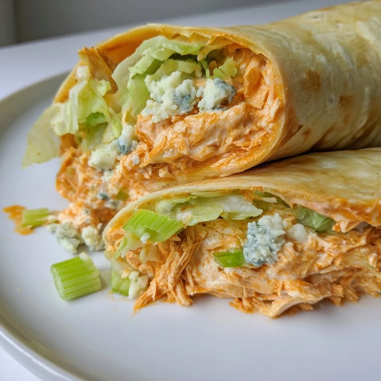 A close-up of a perfectly grilled Buffalo chicken dip wrap, showcasing its savory, meaty interior.
