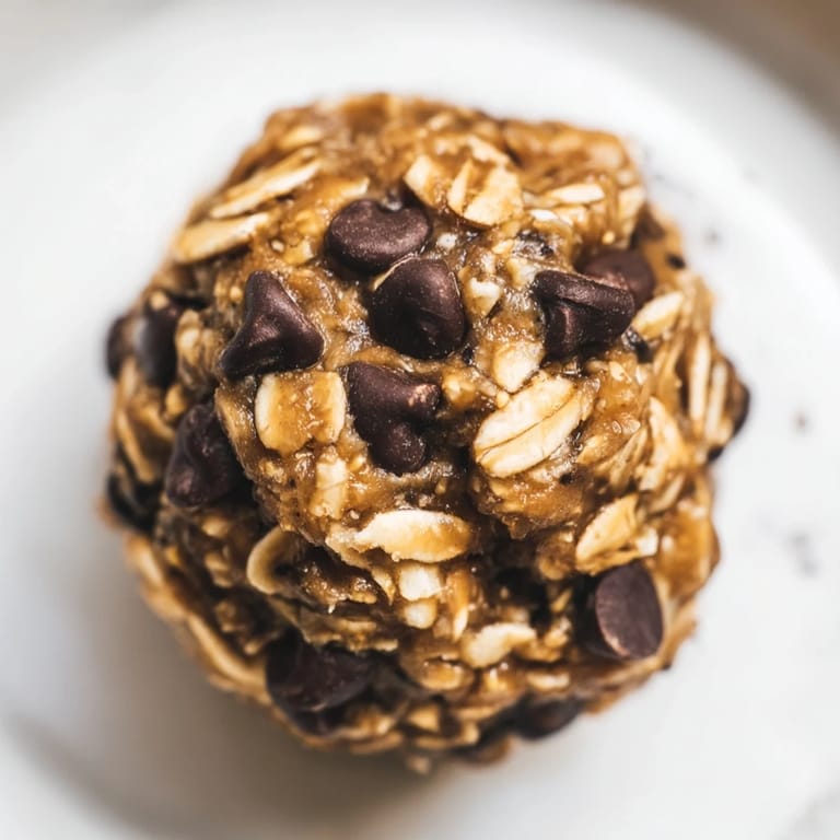 Close-up of no-bake Banana Chocolate Chip Energy Balls, showcasing sticky texture and melty mini chocolate chips in an American-style snack.