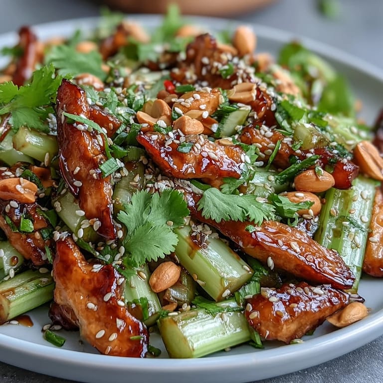 Refreshing celery peanut salad tossed with colorful bell peppers, scallions, and a tangy soy ginger dressing, topped with crunchy sesame seeds.