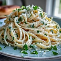 Bright lemon butter pasta with tender peas and Parmesan, a vibrant spring dish in a creamy, golden sauce.