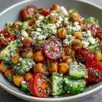 Cold Chickpea Salad with Lemon Herbs, featuring fresh cucumbers, tomatoes, and zesty lemon dressing in a vibrant bowl.  
